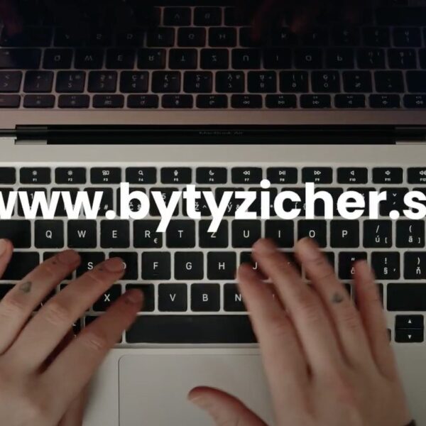 Na záber je zameraný na notebook, na ktorom sú položené ruky a popis www.bytyzicher.sk, tento obrázok je odkazom na registračný web projektu Byty Zicher