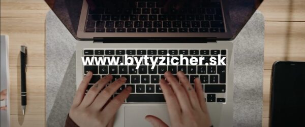 Na záber je zameraný na notebook, na ktorom sú položené ruky a popis www.bytyzicher.sk, tento obrázok je odkazom na registračný web projektu Byty Zicher
